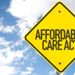 Yellow traffic sign displaying 'Affordable Care Act' against a blue sky