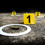 FELON KILLS Neighbor Through Wall Crime scene with evidence markers and a bullet casing on the ground