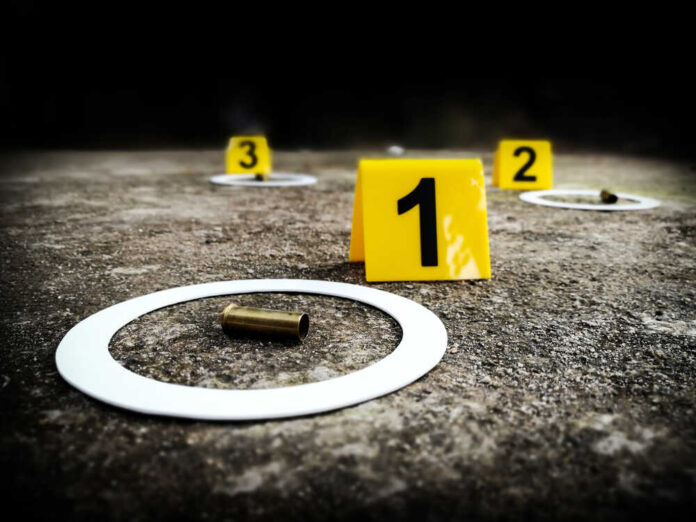 Crime scene with evidence markers and a bullet casing on the ground