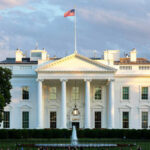 The White House with Washington Monument in background.