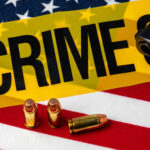 Shocking Shootout: Cops Barely Survive A gun and bullets on an American flag with a crime scene marker