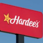 Hardee's restaurant sign against a blue sky