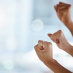 Hands with clenched fists raised in celebration