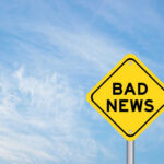 Yellow sign reads bad news in sky