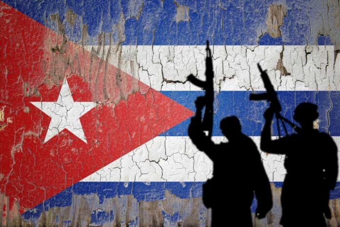 Silhouettes of armed figures in front of a weathered Cuban flag