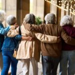 Group of elderly friends walking arm in arm outdoors