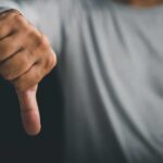 A hand showing a thumbs down gesture