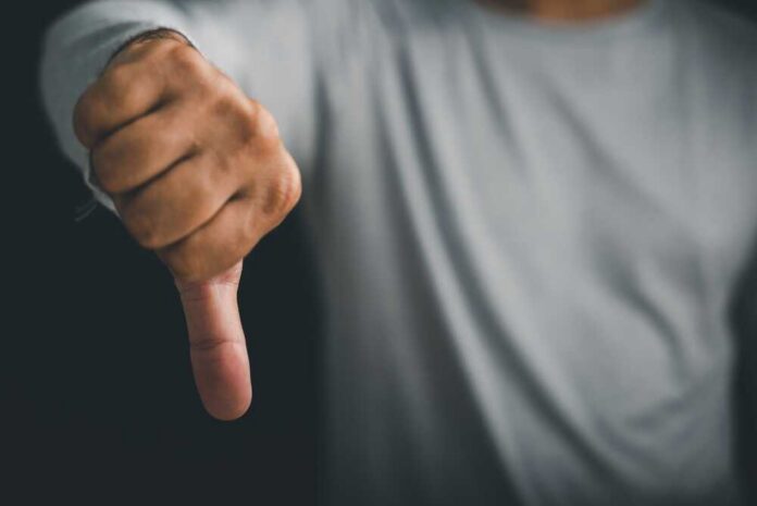 A hand showing a thumbs down gesture