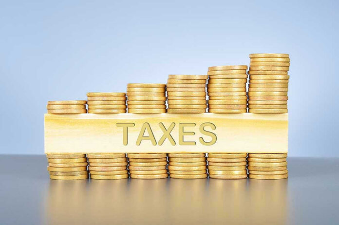 379014430 Stacked coins with TAXES on block beneath.