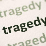 Close-up of the word 'tragedy' printed multiple times in varying shades