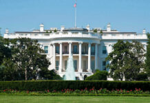 The White House, front view with fountain and flag.
