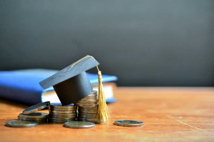 shutterstock_1427912792.jpg Graduation cap on top of coins to represent student loans