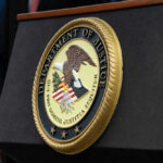 Department of Justice seal on a podium.
