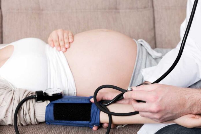 Doctor measuring blood pressure of a pregnant woman