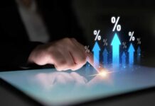 A hand touching a tablet screen with upward arrows and percentage symbols