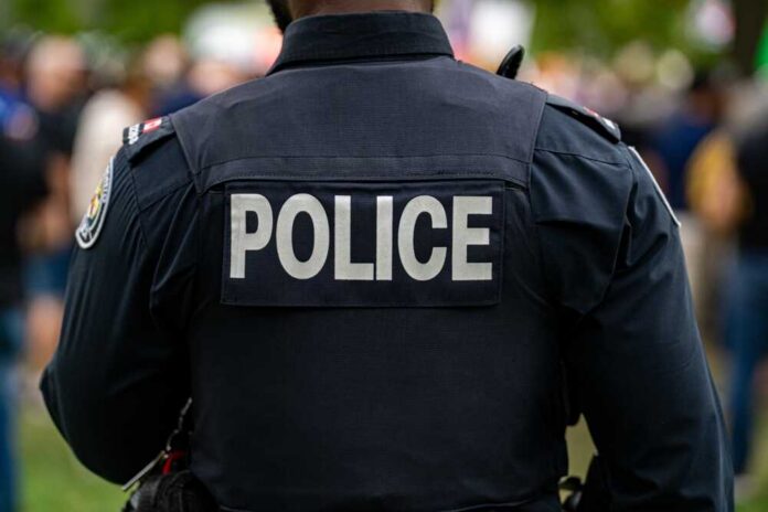 Back view of a police officer wearing a uniform with 'POLICE' displayed