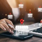 Person using a laptop and smartphone with digital shopping icons