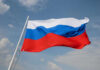 Russian flag waving against a cloudy sky.