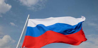 Russian flag waving against a cloudy sky.