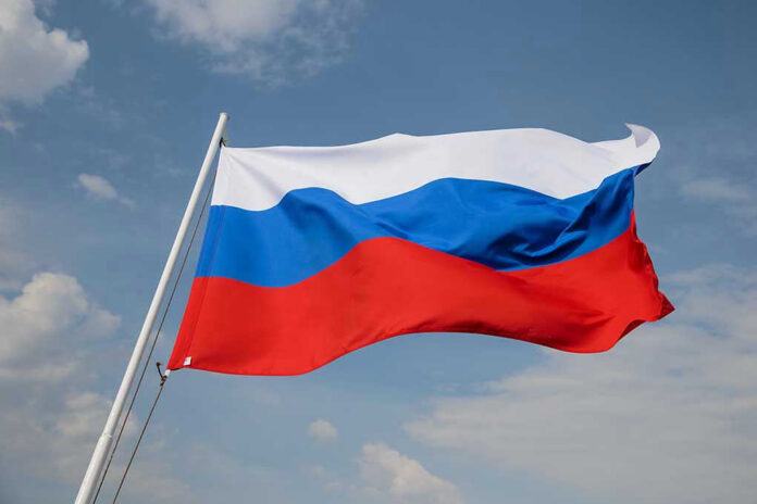 Russian flag waving against a cloudy sky.