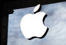 Illuminated Apple logo on a glass storefront