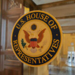 U.S. House of Representatives seal on glass door.