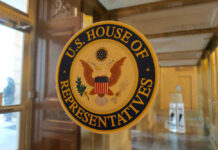 U.S. House of Representatives seal on glass door.