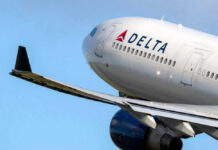 Delta airplane in flight with blue sky background.