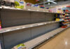 Empty supermarket shelves with sparse products displayed