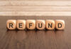 Wooden blocks spelling refund on table