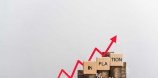 Graph showing inflation trend with coins and wooden blocks