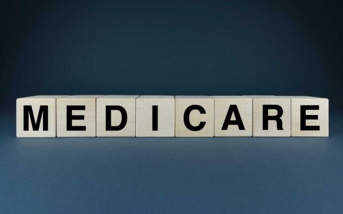 Wooden blocks spelling out MEDICARE on a dark background