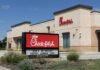 Exterior view of a Chick-fil-A restaurant with a promotional sign