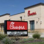 Exterior view of a Chick-fil-A restaurant with a promotional sign
