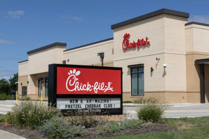 Exterior view of a Chick-fil-A restaurant with a promotional sign