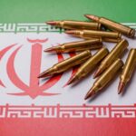 A collection of bullets resting on the Iranian flag