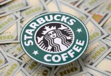 Starbucks coffee logo placed on a background of hundred dollar bills