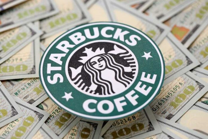Starbucks coffee logo placed on a background of hundred dollar bills