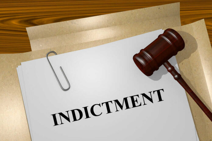 Gavel on a white paper with the word indictment on it.