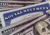 A Social Security card placed on top of U.S. hundred dollar bills