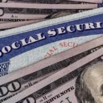 A Social Security card placed on top of U.S. hundred dollar bills