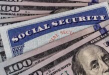 A Social Security card placed on top of U.S. hundred dollar bills