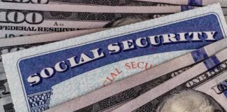 A Social Security card placed on top of U.S. hundred dollar bills