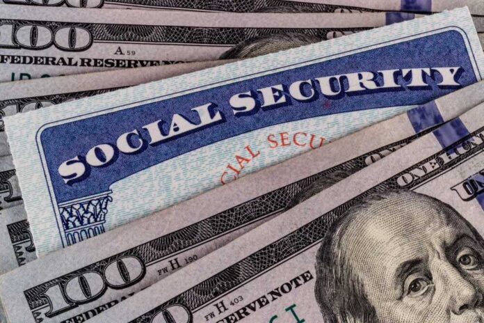 A Social Security card placed on top of U.S. hundred dollar bills