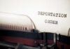 Close-up of a typewriter with a paper showing the words 'DEPORTATION ORDER'