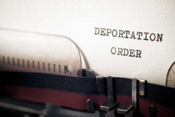 Close-up of a typewriter with a paper showing the words 'DEPORTATION ORDER'
