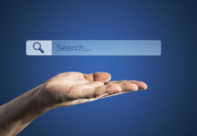A hand holding an invisible search bar with a magnifying glass icon