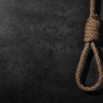 A noose made of rope hanging against a dark textured background