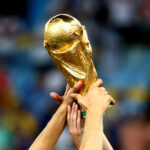 Hands holding the FIFA World Cup trophy aloft in celebration