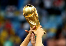 Hands holding the FIFA World Cup trophy aloft in celebration